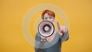 Redhead woman in 40s speaking in loudspeaker