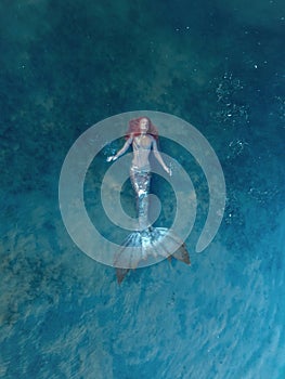 redhead woman as mermaid in the lake