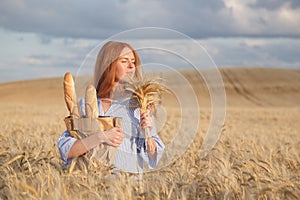 Redhead woman with bakery products in ripe wheat field