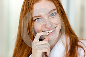 Redhead woman in bathrobe looking at camera