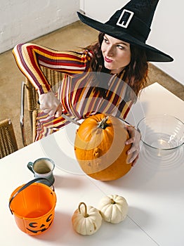 Redhead woman cutting a pumpkin for Halloween