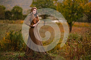 Redhead woman in dress walking in fantasy fairy tale forest