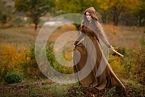 Redhead woman in dress walking in fantasy fairy tale forest