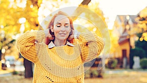 Redhead woman enjoying life outdoors. Happy woman walking in autumn park. Autumn fashion, lifestyle and holidays