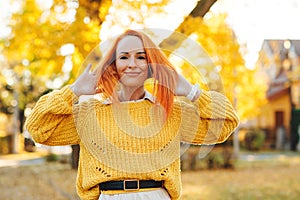 Redhead woman enjoying life outdoors. Happy woman walking in autumn park. Autumn fashion, lifestyle and holidays