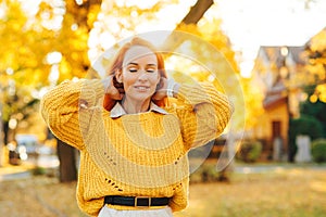 Redhead woman enjoying life outdoors. Happy woman walking in autumn park. Autumn fashion, lifestyle and holidays