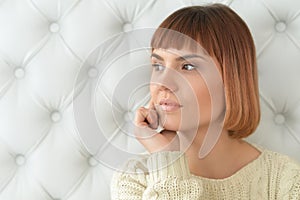 Redhead woman with hand on chin