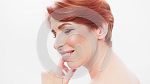 Redhead woman in her 40s posing against white background. Beauty shot