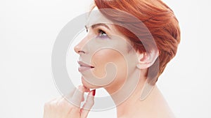 Redhead woman in her 40s posing against white background. Beauty shot