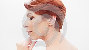 Redhead woman in her 40s posing against white background. Beauty shot