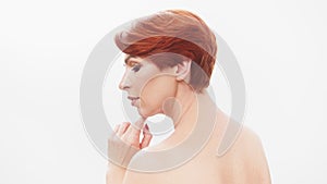 Redhead woman in her 40s posing against white background. Beauty shot