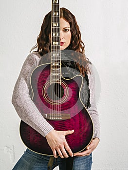Redhead woman holding acoustic guitar