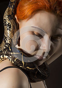 Redhead woman holding snake. close-up photo girl with pygmy python on a white background