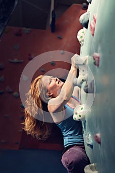 Redhead Woman Indoor Rock Climbing. Strong Heroic Female Climber