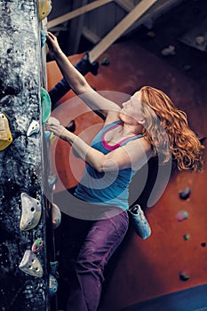 Redhead Woman Indoor Rock Climbing. Strong Heroic Female Freeclimbing