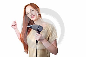 Redhead woman with long hair holding hair dryer