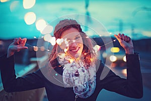 Redhead woman pulling apart garland fairy lights