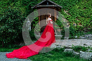 Redhead woman in red dress near the castle