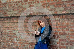 Redhead woman sending message with smartphone