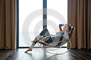 Redhead woman sitting on rocking chair