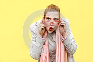 Redhead woman wearing coat, opening mouths widely, having surprised shocked looks.