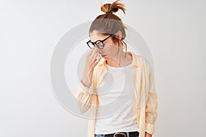 Redhead woman wearing striped shirt and glasses standing over isolated white background tired rubbing nose and eyes feeling