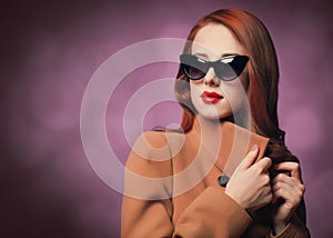 Redhead woman in yellow coat and black sunglasses