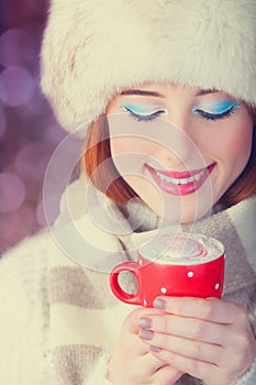 Redhead women with cup of coffee.