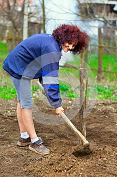 Redhead young lady digging in the garden