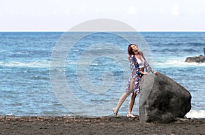 The redhead young woman standing at the sea