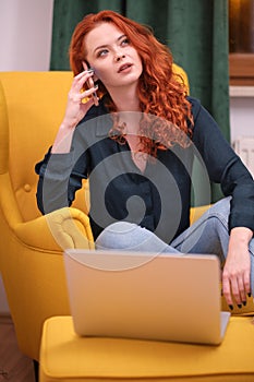 Redhead young woman using laptop at home. covid isolation. home office