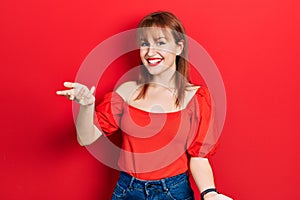 Redhead young woman wearing casual red t shirt smiling cheerful with open arms as friendly welcome, positive and confident