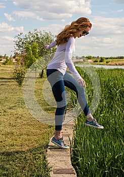 Redheaded model is teetering on the parapet