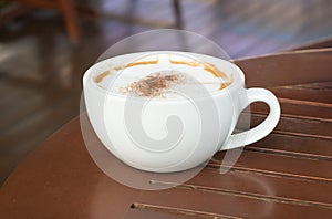 Redolent cappuccino coffee on wooden table.