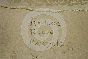 Reduce reuse recycle concept drawn on sand, sustainability photo