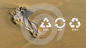 Reduce, reuse, recycle symbol on Plastic bag are left on the beach as waste polluting nature, ecological metaphor for ecological