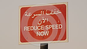 Reduce speed sign in arabic and english