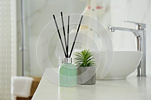 Reed air freshener and houseplant on counter photo