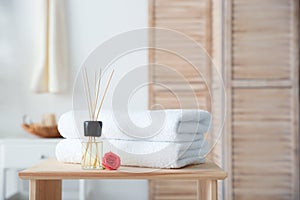 Reed air freshener and stack of towels