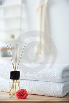 Reed air freshener and stack of towels on table