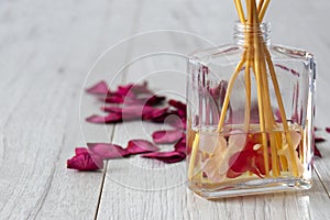 Reed diffuser with fragrance in a glass jar with rose petals