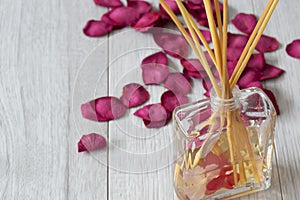 Reed diffuser with fragrance in a glass jar with rose petals