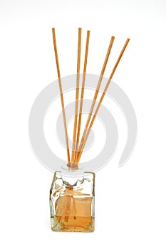 Reed diffuser, with reed sticks in a bottle of scented oil, on w