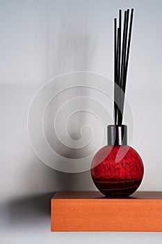 reed diffuser on shelf with shadows on wall