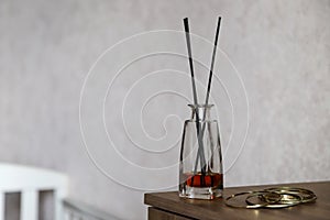 Reed diffusor in domestic interior. Cozy home atmosphere. Concept of relaxation with aromatherapy. Photo with copy space