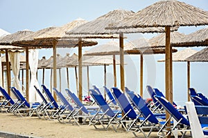 Reed umbrellas and deck chairs at the beach