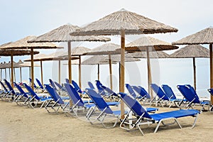 Reed umbrellas and deck chairs at the beach