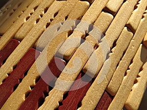 Reed or wood mat. The rug is a mat under the hot. Knitted processed wood sticks with rounded edges. Close-up. Yellow, brown and