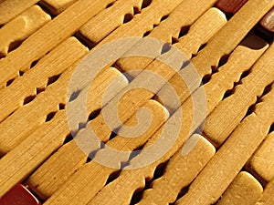 Reed or wood mat. The rug is a mat under the hot. Knitted processed wood sticks with rounded edges. Close-up. Yellow, brown and