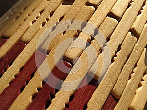 reed or wood mat. The rug is a mat under the hot. Knitted processed wood sticks with rounded edges. Close-up. Yellow  brown and